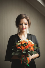 Luxury bride in black robe posing while preparing for the wedding ceremony