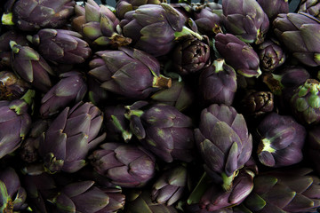 Insieme di carciofi violetti  freschi raccolti e posati su un tavolo