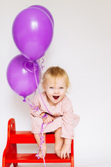 llittle girl sitting on the bench with pink balloon