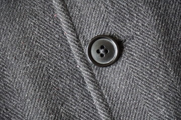 Detail of a dark button fastening the fish bone winter coat 