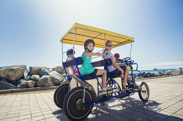 Fototapeta na wymiar Family on a surrey bike ride along the coast of California