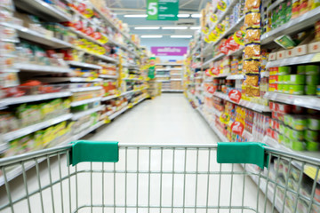 Shopping in supermarket shopping cart view with motion blur