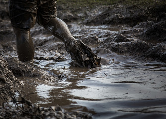 Deep muddy water with feet splashing through and dragging the mud in a race - 105029085