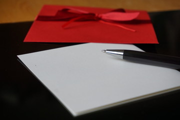 Black pen writing announcement letter with the decorated red envelope 