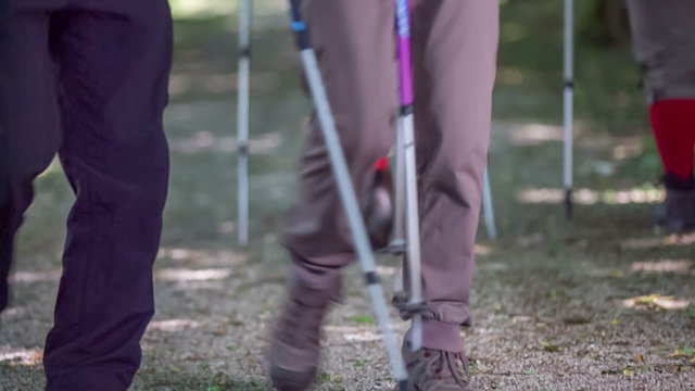 Four elderly people are hiking, showing their feet only
