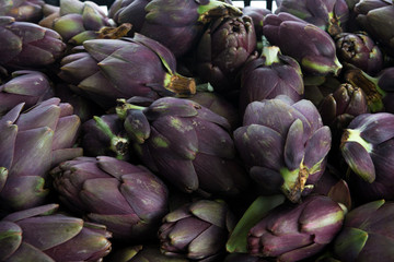 Fototapeta na wymiar Insieme di carciofi violetti freschi raccolti e posati su un tavolo