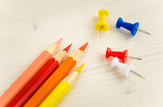 Wooden Crayons and Pushpins with wooden Backgound