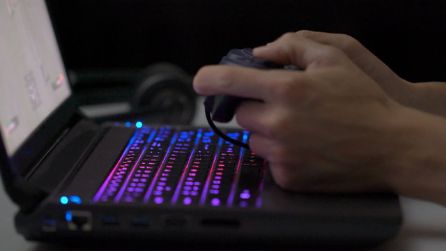 Playing computer game on laptop with joypad