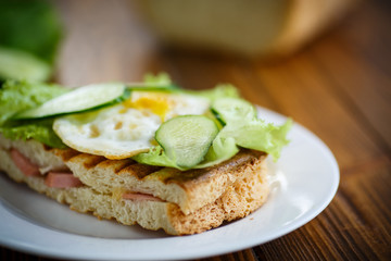 sandwich with sausage, cheese, lettuce and eggs