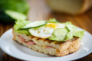 sandwich with sausage, cheese, lettuce and eggs