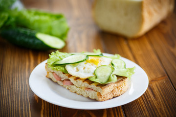 sandwich with sausage, cheese, lettuce and eggs
