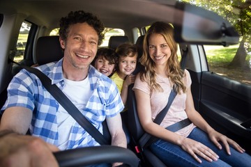Smiling family sitting in the car