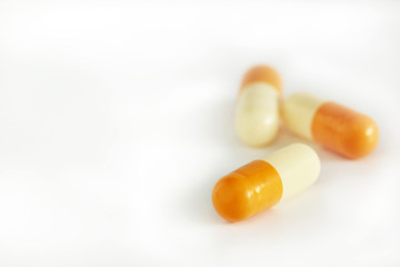 three yellow capsule on white