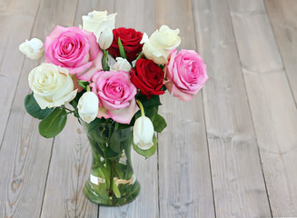 Bouquet with roses and tulips in a vase.