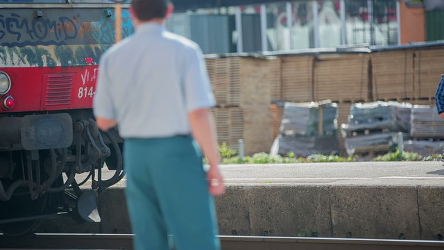 Conductor give a sign to the driver of a train that he can drive off