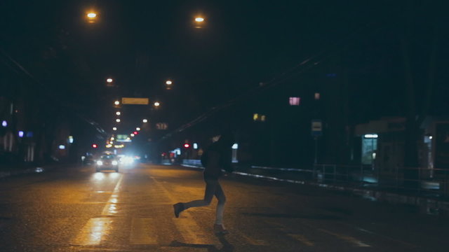 Night view of Crosswalk. Teen girl runs across the road in front of the vehicle. A dangerous situation. RAW video record.