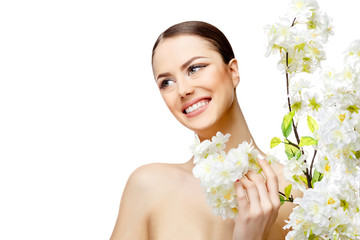 Beautiful Woman with Clean Fresh Skin holding flowering branches