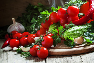 Fresh cherry tomatoes with spring vegetables and herbs, still li