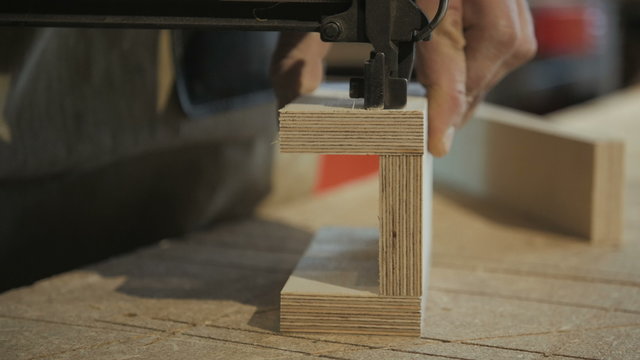 Worker Using Staple Gun to Fix Wood Parts