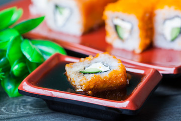 Sushi roll with salmon and shrimp tempura on wooden table