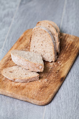 A slice of bread with butter on a chopping board.