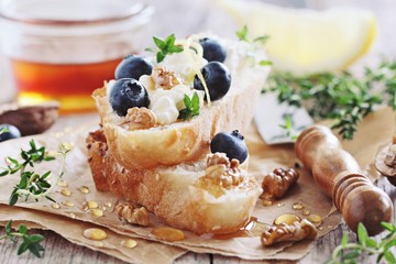 Sandwich  with cottage cheese, blueberries,walnuts and honey. Toned image.Selective focus