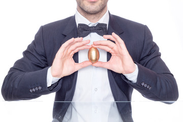Businessman holding a golden egg for Easter 