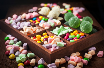 Mix of candies and sweets in wooden box