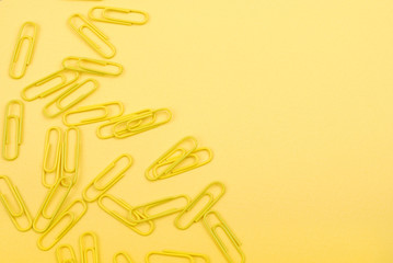 yellow paper clips on a yellow sheet of paper