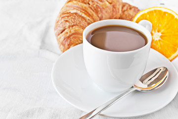 Cup of coffee,orange and croissant.