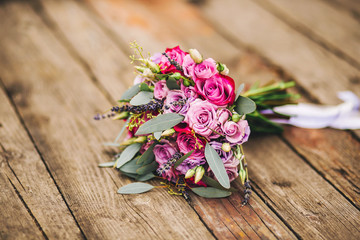 Roses, peonies and mix of summer flowers bouquet on wood background for the wedding in Europe