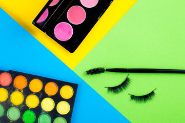 cosmetics for makeup. bright blue background with green eyelashes glamorous and trendy