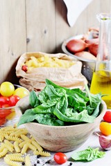 Spinach,pasta,tomatoes,spices.Traditional Italian food ingredients.Selective focus