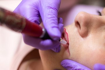 Cosmetologist applying permanent makeup on lips
Selective focus and shallow Depth of field
