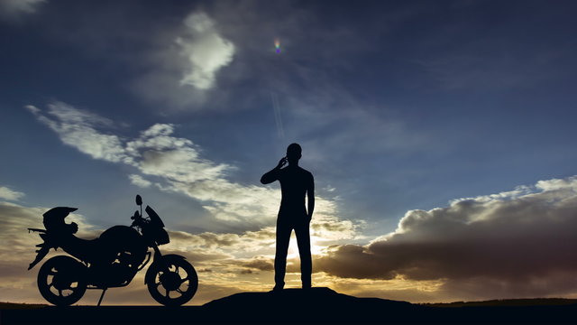 The man stand near motorcycle on the background of clouds. Real time capture. Wide angle