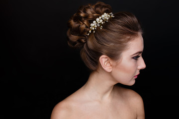 Beautiful young woman with bare shoulders, dark background