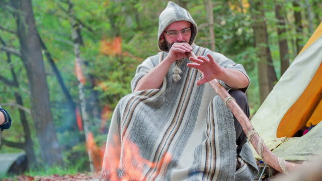 Playing didgeridoo near camp fire