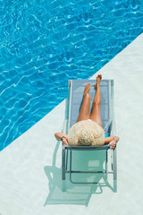 woman enjoying on sunbed at swimming pool