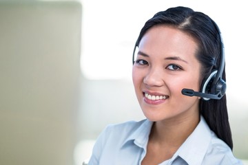 Composite image of smiling businesswoman using headset