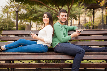 Happy young couple using technology