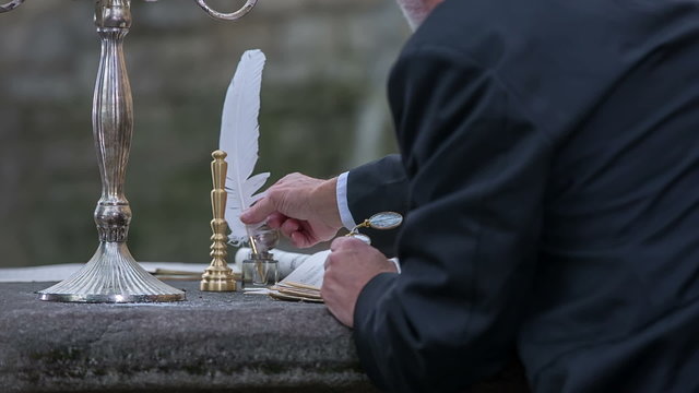 Man picking up the feather to start writing