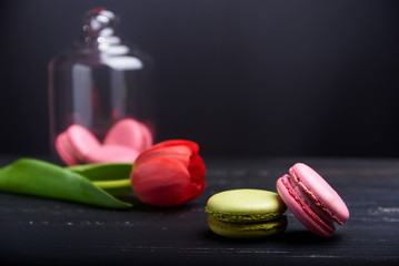 pink and green macaroons on a black wooden table