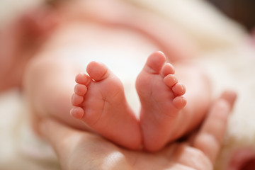 Mother holds in his hands a small baby foots