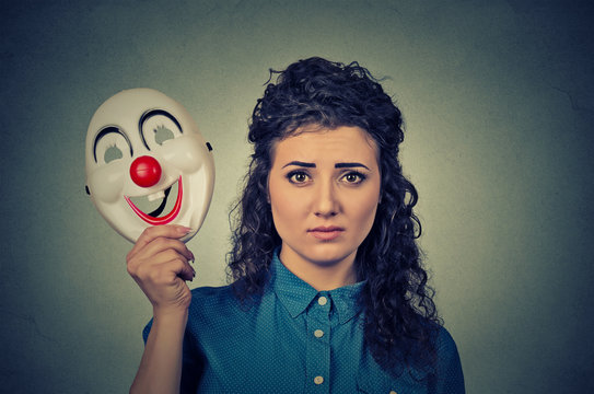 upset worried woman with sad expression holding clown mask expressing cheerfulness