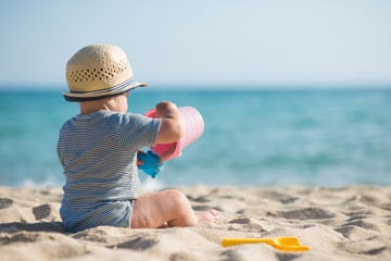 Cute little boy playing toys on the seashore