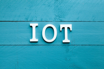 The acronym IOT Internet of things on blue background