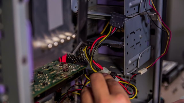 A repairman is trying to fix something on a computer