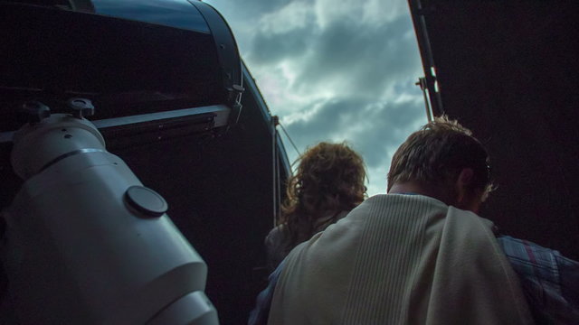 Couple looks trough the window in a observatory