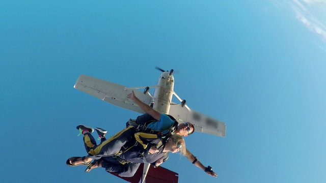 Young woman and her instructor jumping off a plane