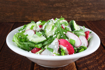 Salad with arugula, cucumber, cottage cheese and radish